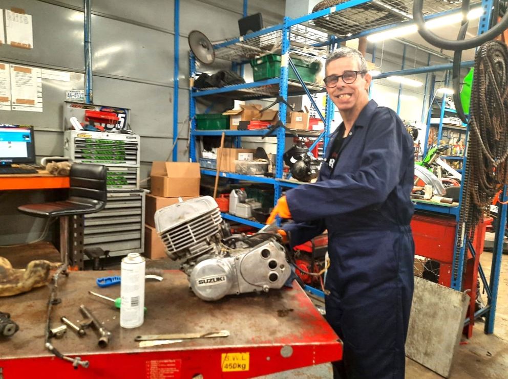 Darren, a man with learning diabilities supported by ambient, is volunteering at his local mechanic garage