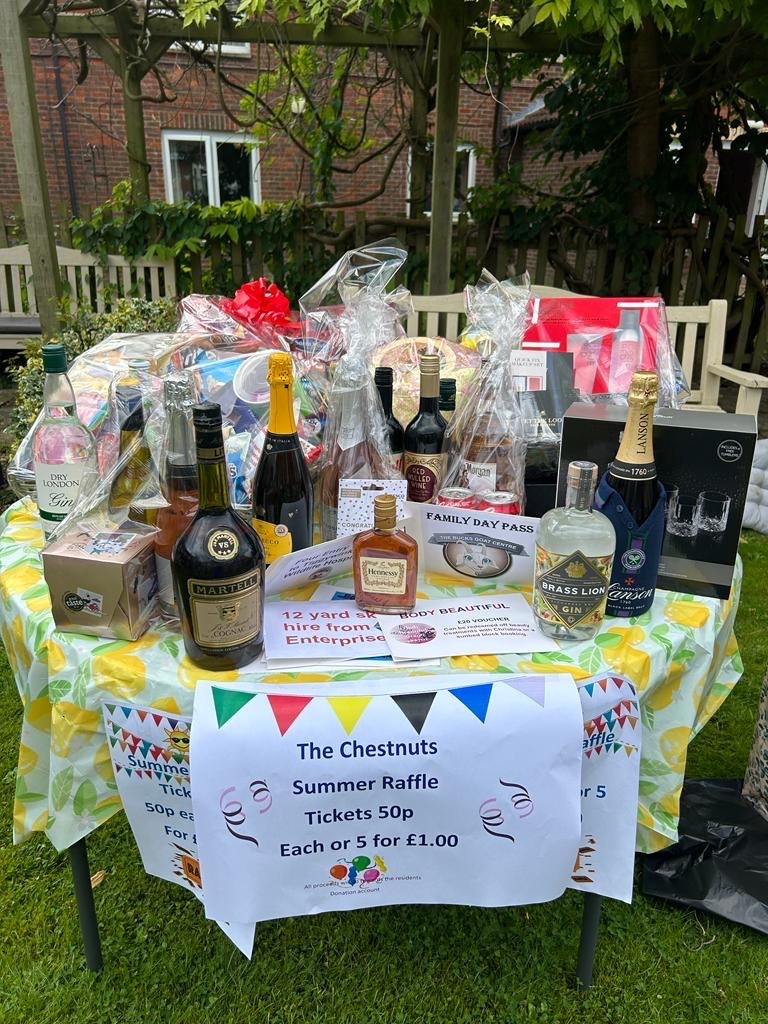 a table full of raffle prizes, some alcoholic beverages, chocolate and much more