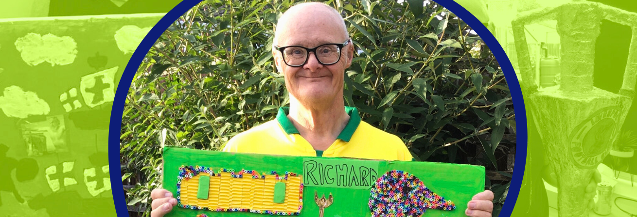 Richard, a man with Down Syndrome, holds up a piece of artwork he has made. There is a green background with opaque images of other pieces of his art.
